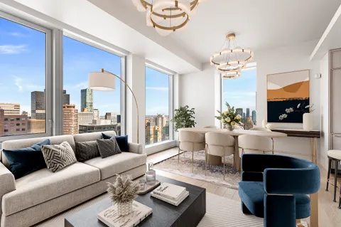 a living room with furniture a chandelier and a flat screen tv