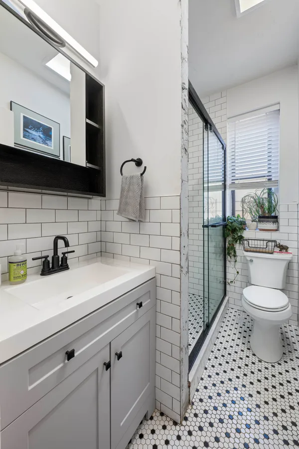 a bathroom with a sink a toilet and shower