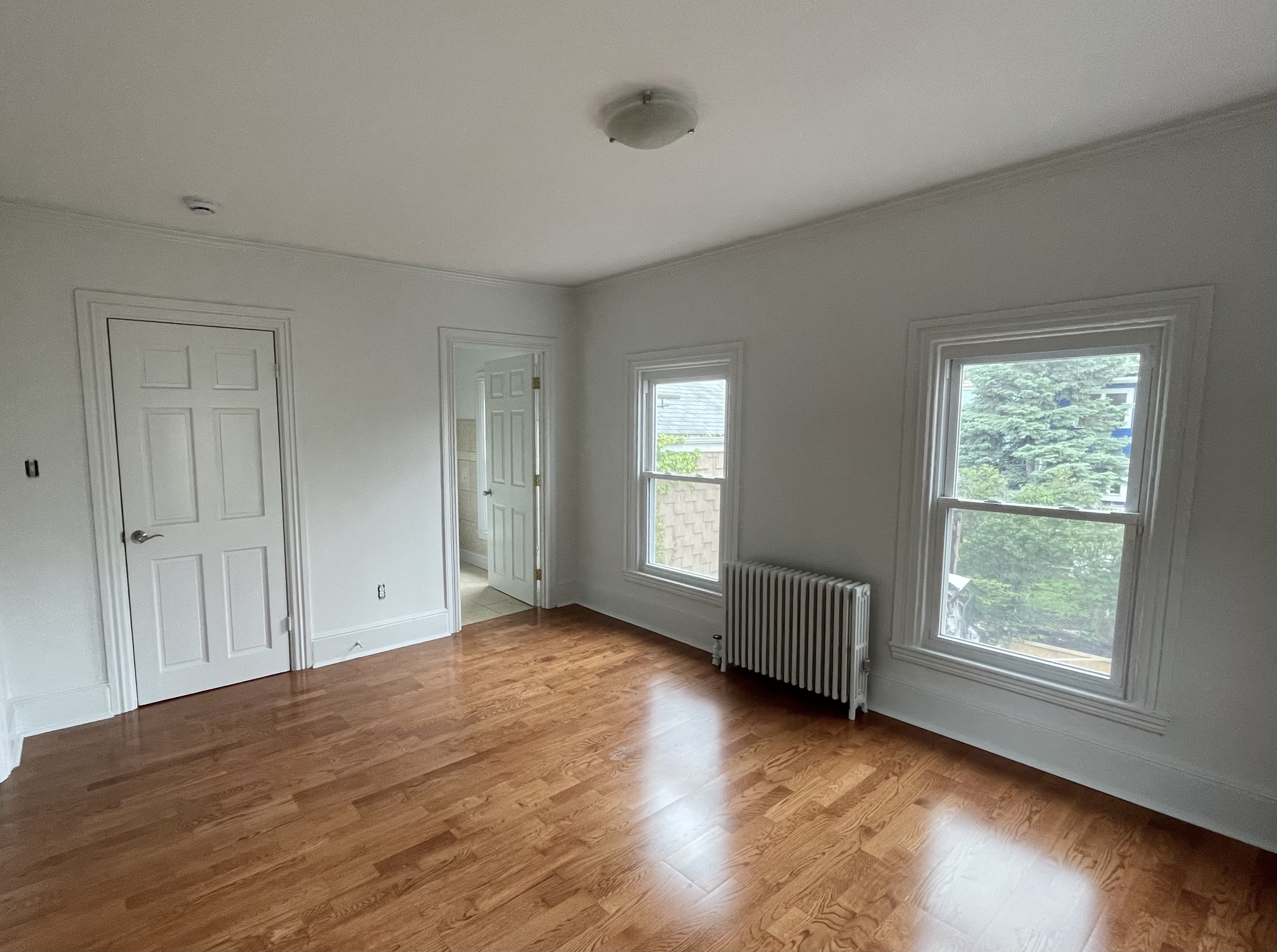 49 8th Street Cambridge, MA 02141 - Photo 4 of 6 an empty room with wooden floor and windows