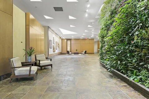 a room with lots of green space and glass windows