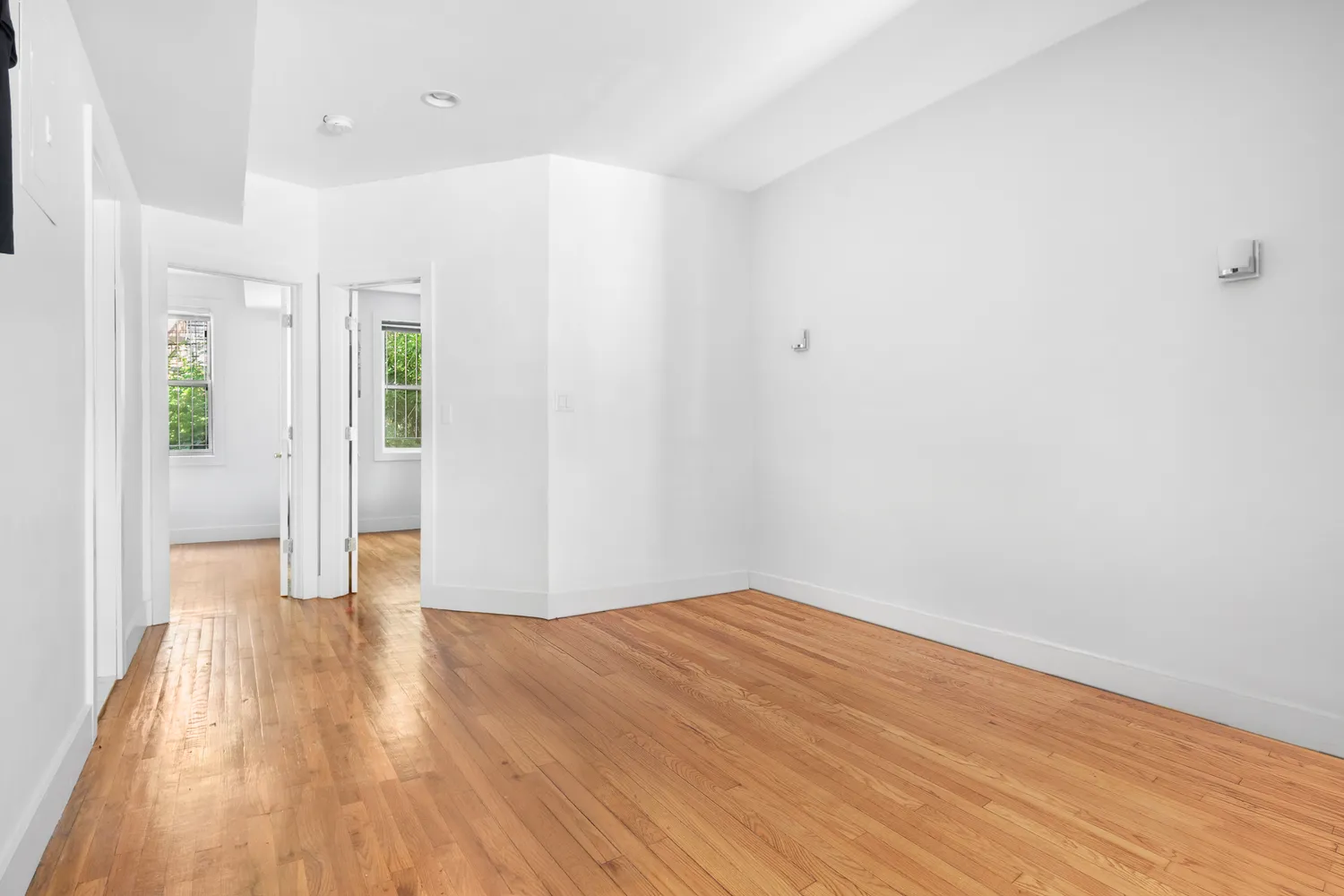 a view of an empty room with wooden floor