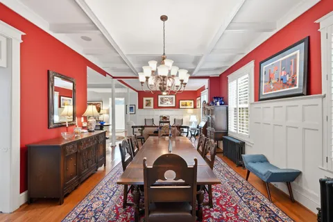 a living room with furniture a chandelier and a dining table