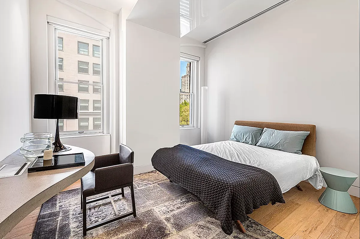 186 5th Avenue, Unit 4A Manhattan, NY 10010 - Photo 5 of 12 a bedroom with a bed and a table in it