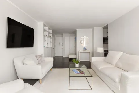 a living room with furniture a flat screen tv and a rug