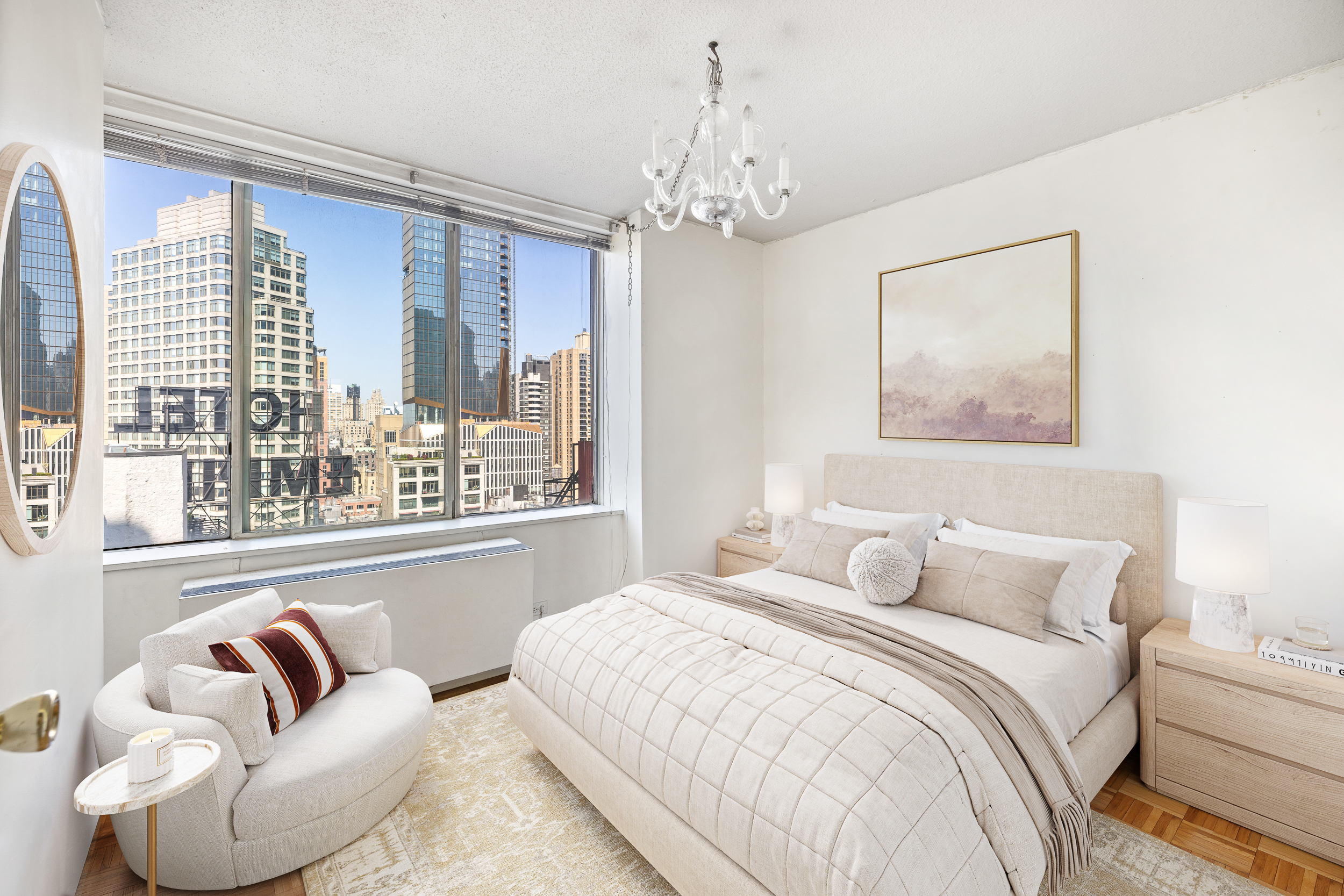 61 West 62nd Street, Unit 19C Manhattan, NY 10023 - Photo 3 of 7 a bedroom with a large bed and a chandelier