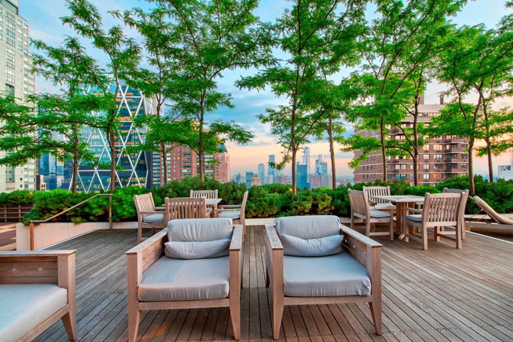 25 Columbus Circle, Unit 75A Manhattan, NY 10019 - Photo 32 of 36 a view of a patio with couches table and chairs with wooden floor and fence