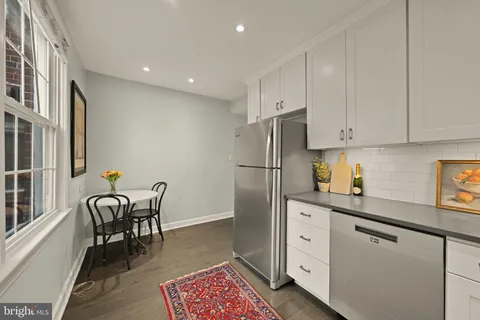 a kitchen with white cabinets and stainless steel appliances