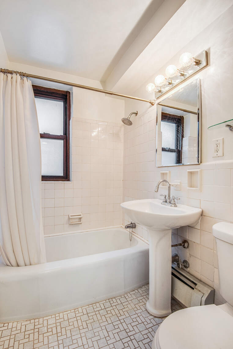305 East 72nd Street, Unit 4CN Manhattan, NY 10021 - Photo 5 of 9 a bathroom with a sink toilet and shower