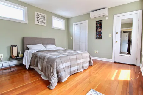 a bedroom with a bed and wooden floor