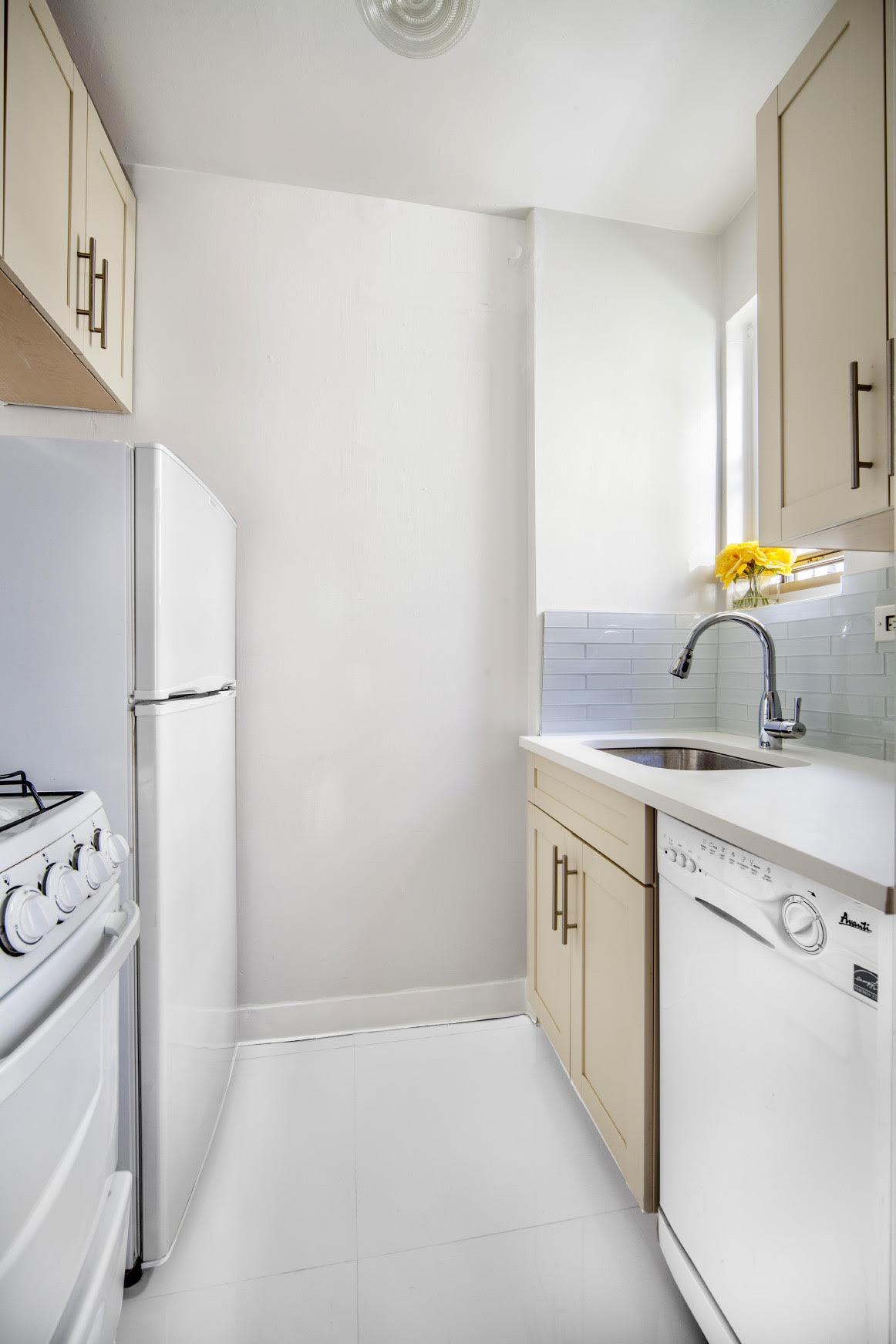 225 East 46th Street, Unit 4K Manhattan, NY 10017 - Photo 5 of 14 a kitchen with a sink stove and refrigerator