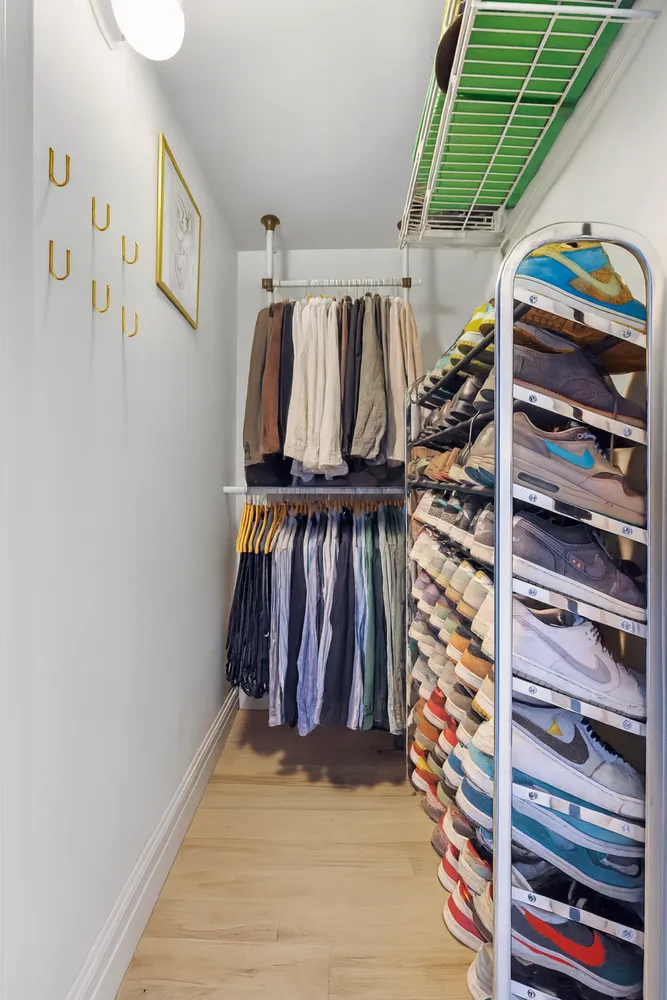 a view of walk in closet with clothes and shoes