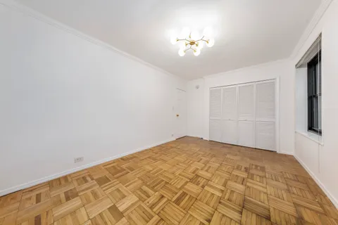 a view of an empty room with a chandelier fan