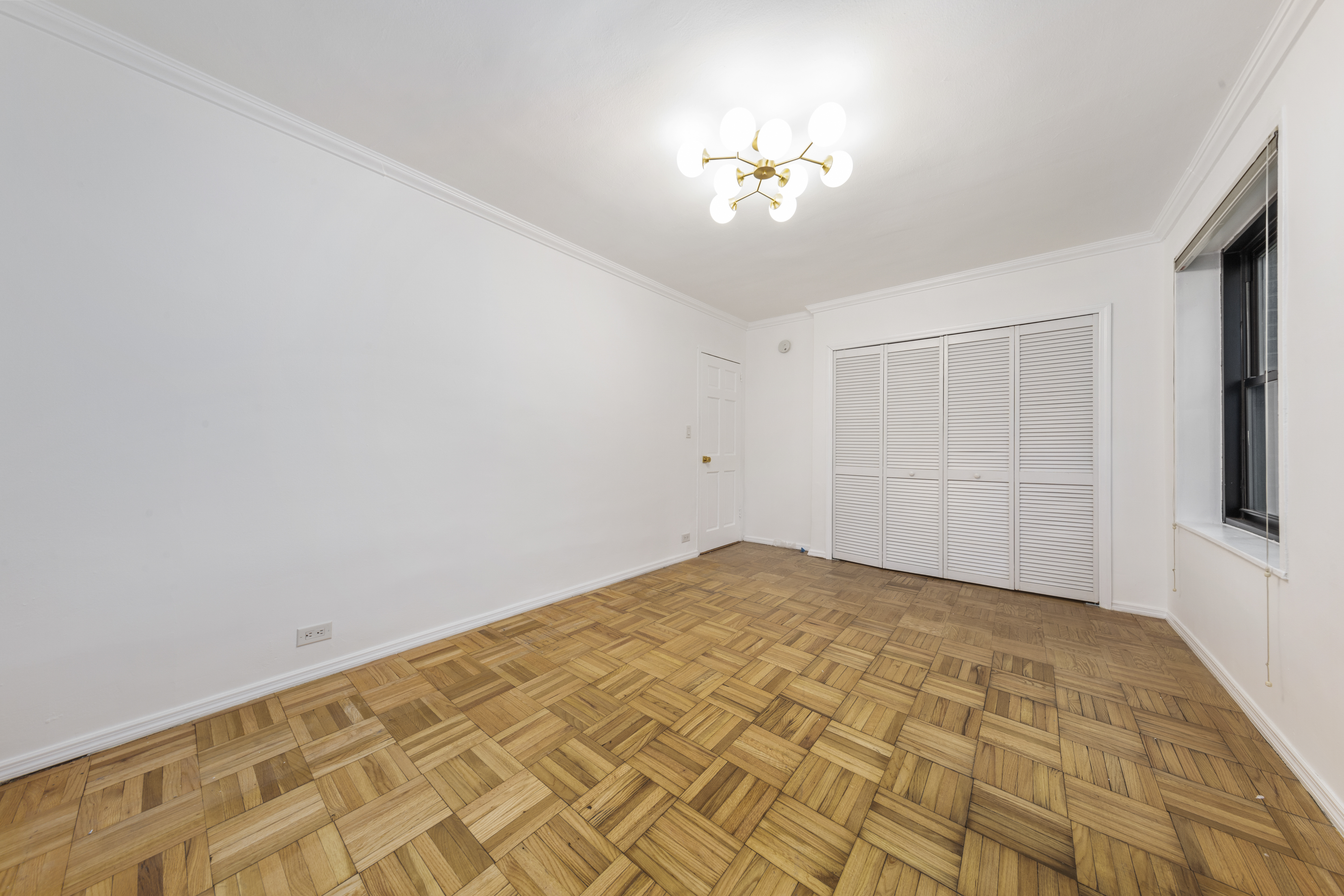 355 Clinton Avenue, Unit F1 Brooklyn, NY 11238 - Photo 8 of 20 a view of an empty room with a chandelier fan