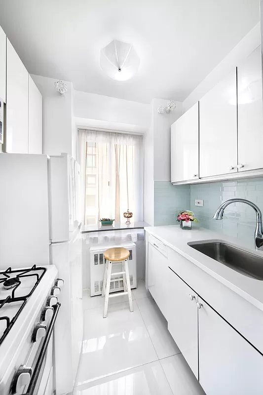 225 East 46th Street, Unit 12G Manhattan, NY 10017 - Photo 3 of 14 a kitchen with a sink stove top oven and cabinets