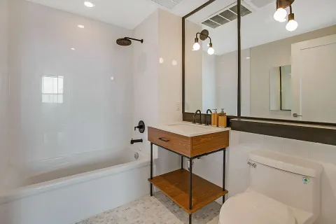 a bathroom with a sink a toilet a mirror and bathtub