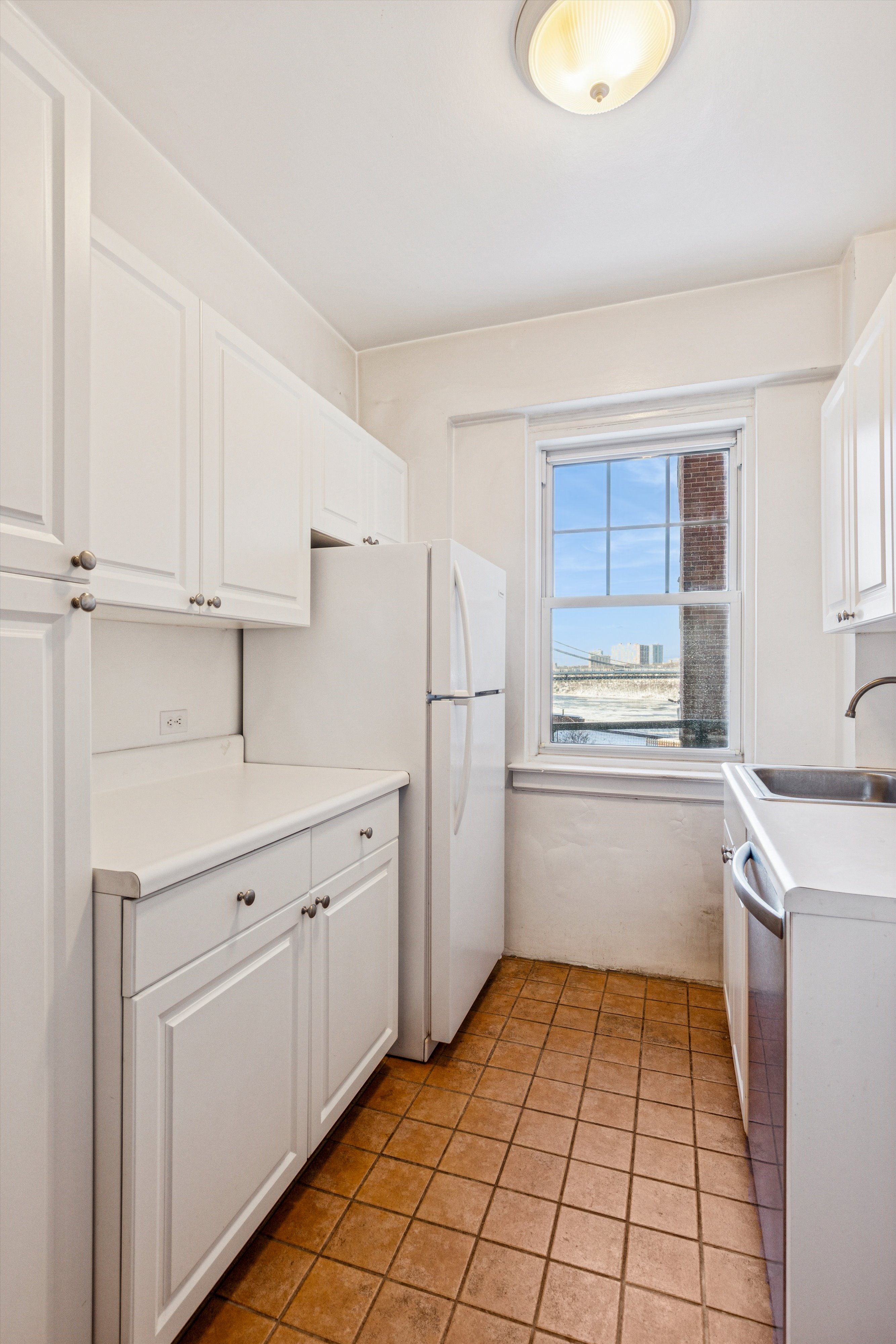 200 Cabrini Boulevard, Unit 10 Manhattan, NY 10033 - Photo 15 of 35 a kitchen with white cabinets and white appliances