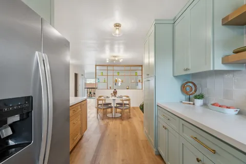 a view of a kitchen with kitchen island and stainless steel appliances