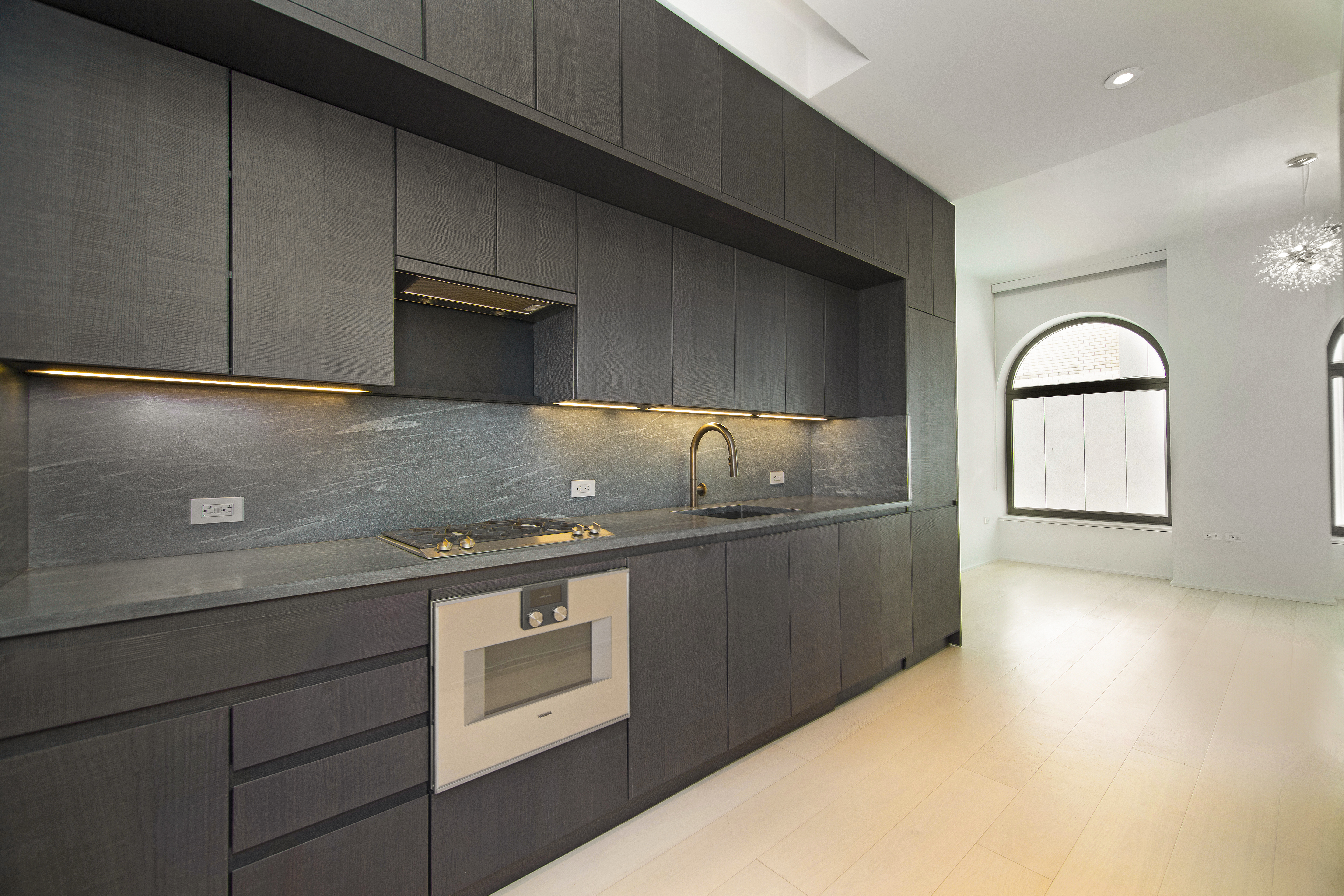 130 William Street, Unit 9E Manhattan, NY 10038 - Photo 7 of 16 a kitchen with granite countertop a sink and a stove top oven