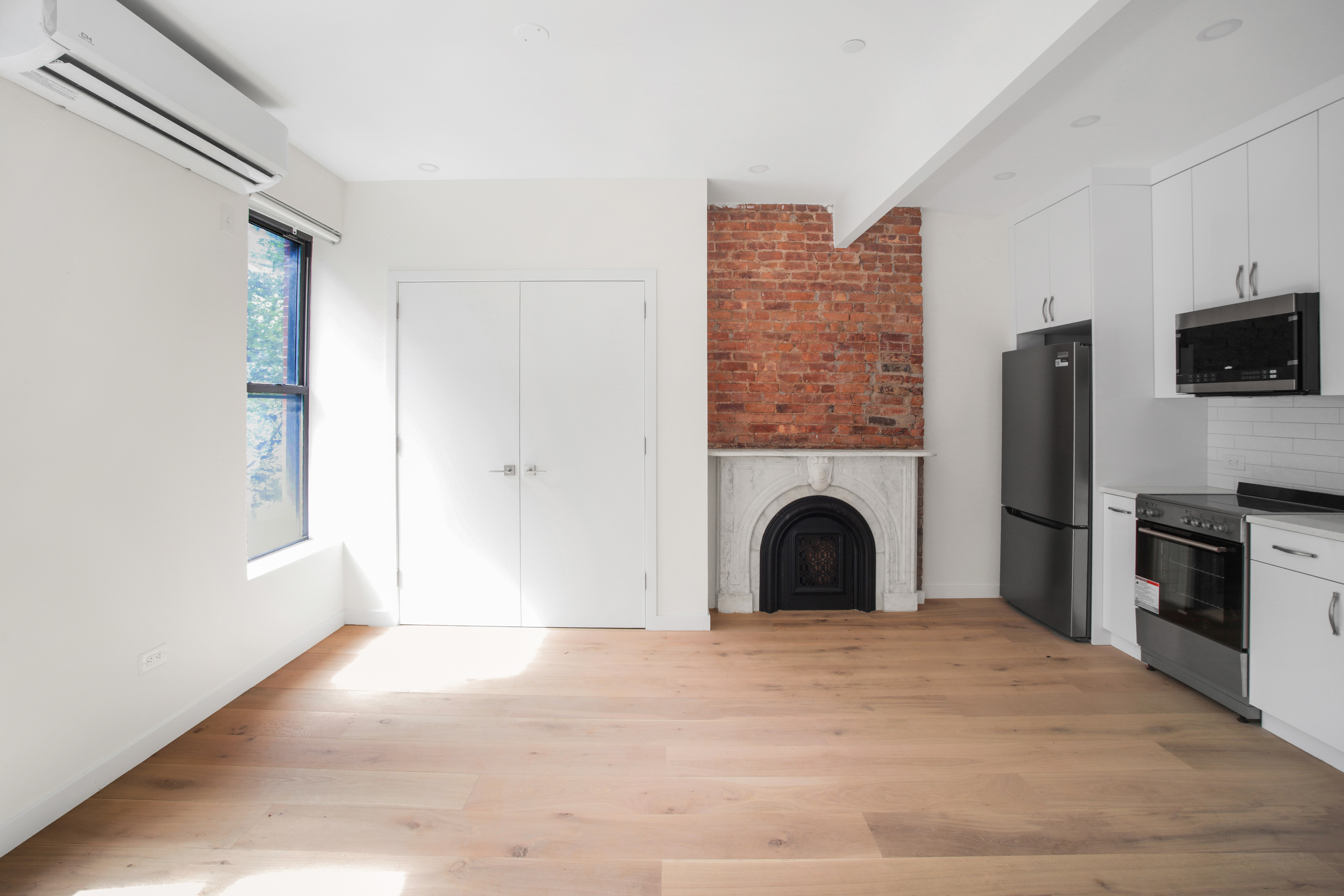 94 6th Avenue, Unit 3F Brooklyn, NY 11217 - Photo 4 of 11 a view of a livingroom with a fireplace and a window