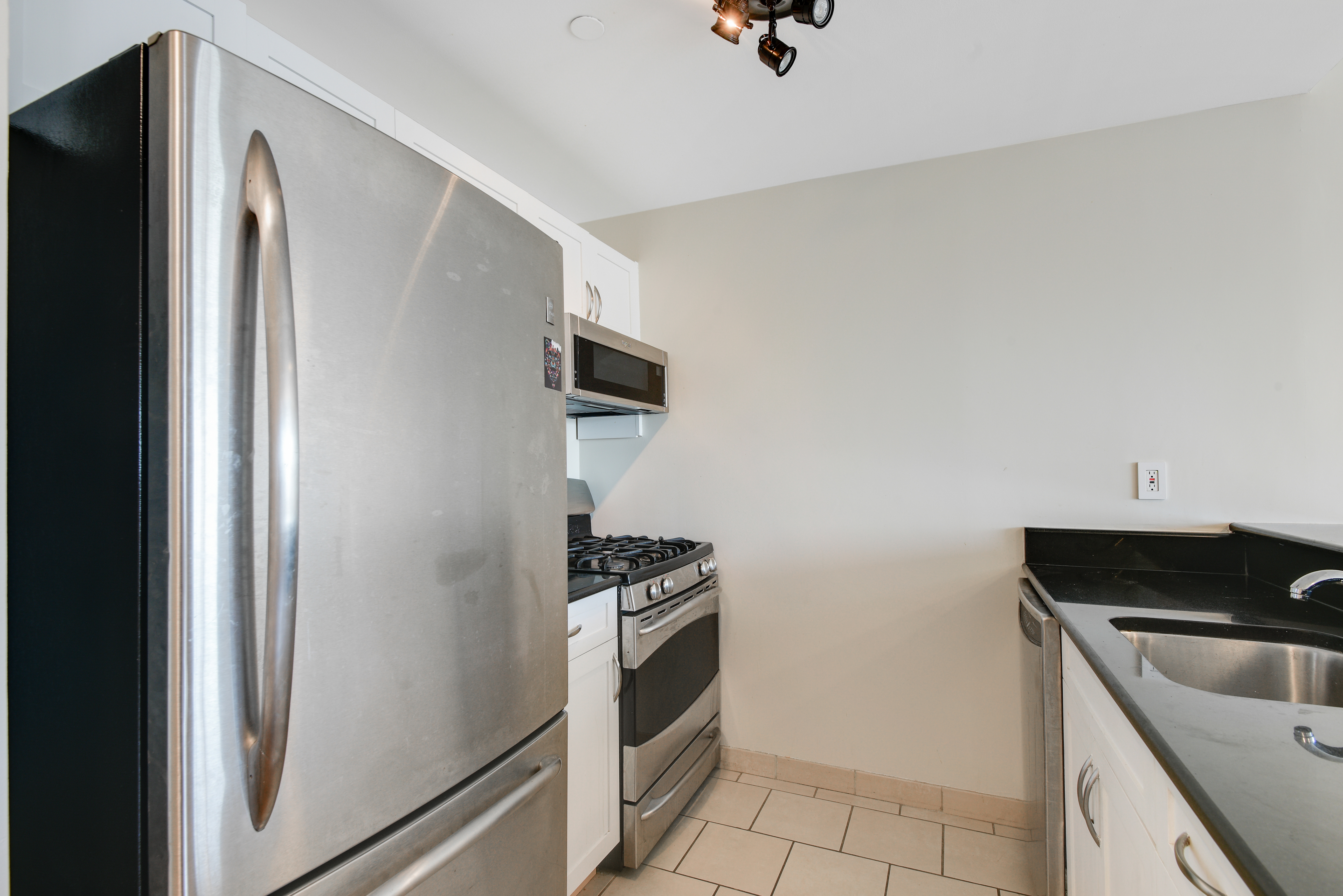 199 Bowery, Unit 11F Manhattan, NY 10002 - Photo 4 of 13 a kitchen with a refrigerator and a sink
