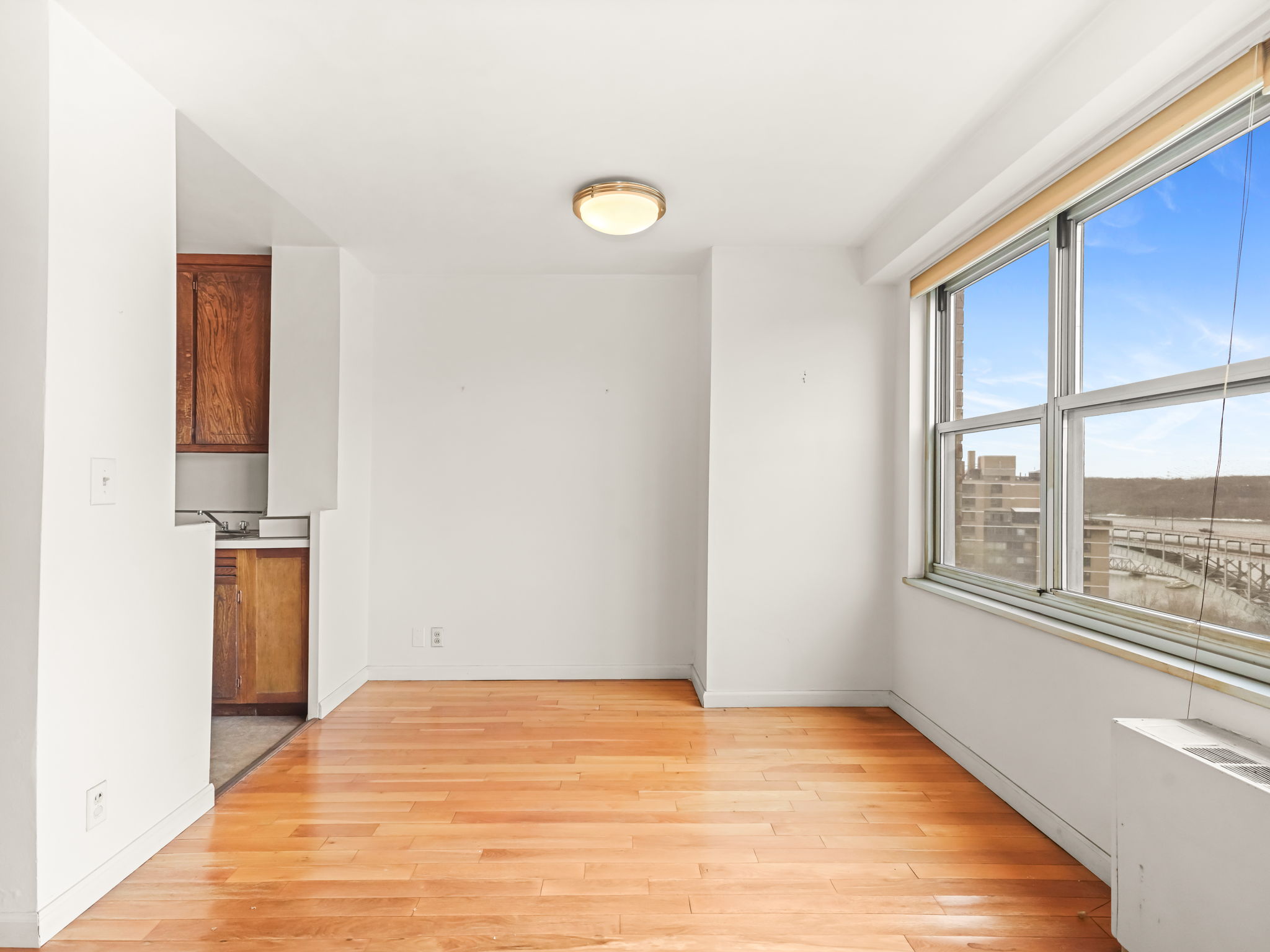 555 Kappock Street, Unit 11J Bronx, NY 10463 - Photo 12 of 24 a view of empty room with wooden floor and fan
