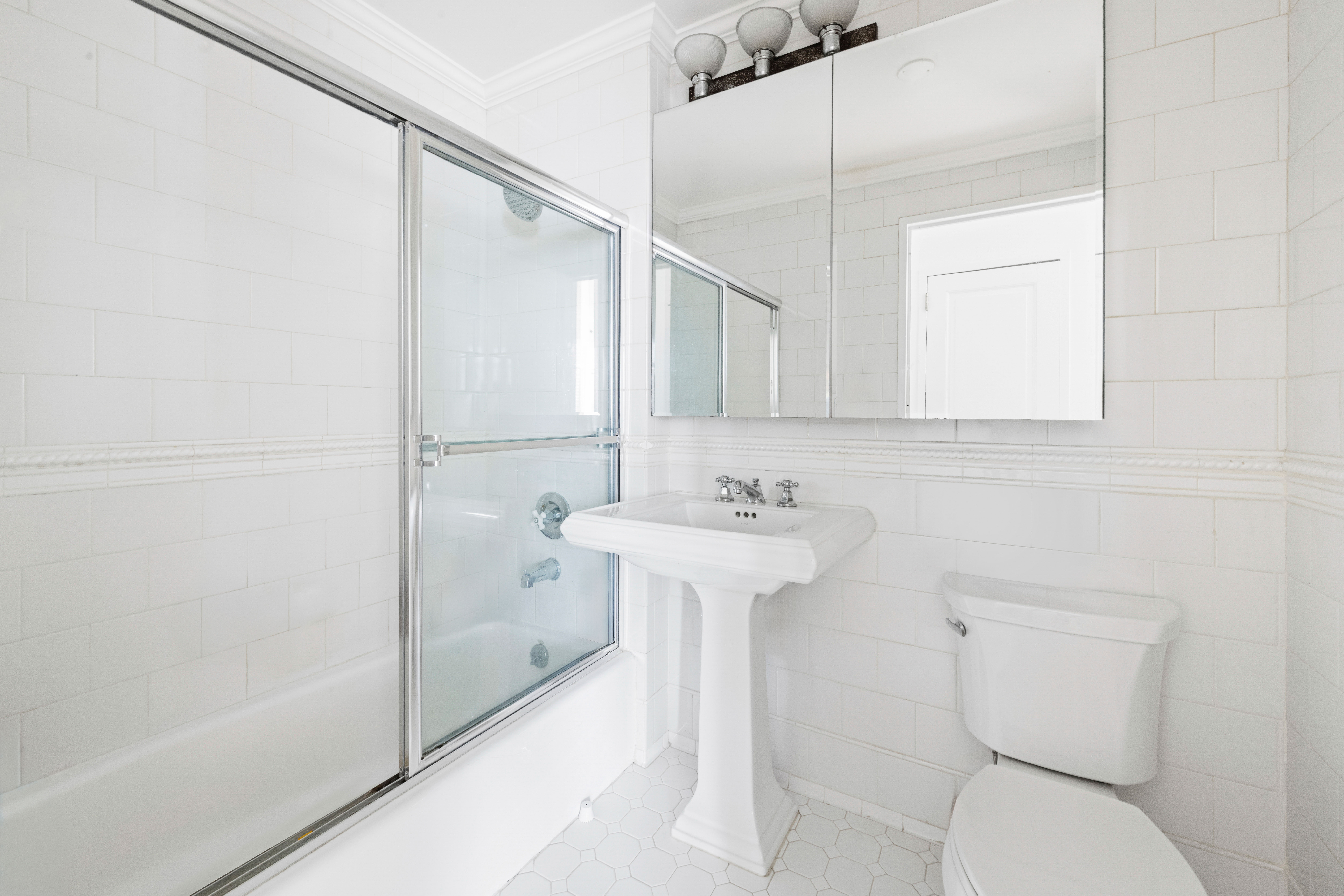 404 East 76th Street, Unit 8A Manhattan, NY 10021 - Photo 11 of 17 a bathroom with a sink a toilet and shower