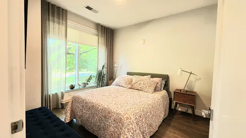 a bedroom with a bed and a flat tv screen on dresser