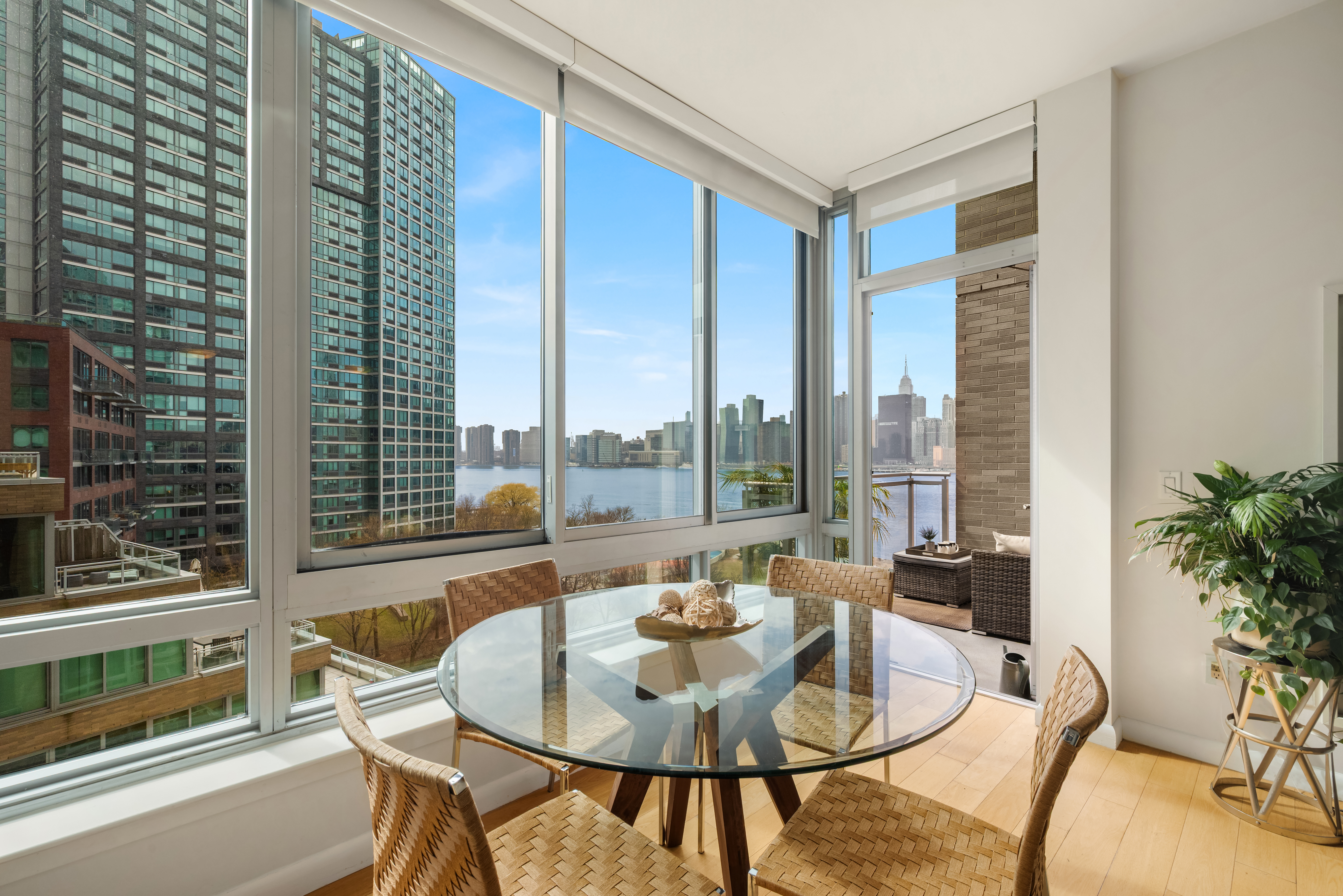 46-30 Center Boulevard, Unit 707 Queens, NY 11109 - Photo 4 of 23 a dining room with furniture and a floor to ceiling window