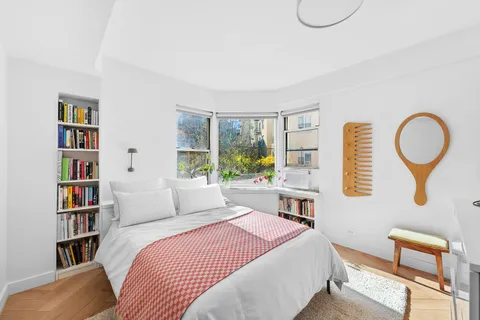 a bedroom with a bed and a book shelf