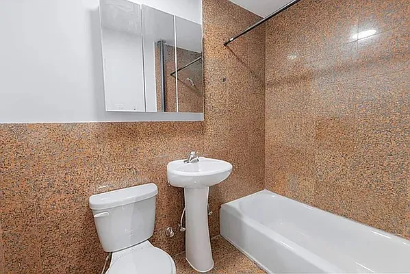 117 Mulberry Street, Unit 21 Manhattan, NY 10013 - Photo 4 of 4 a bathroom with a sink a toilet and a mirror