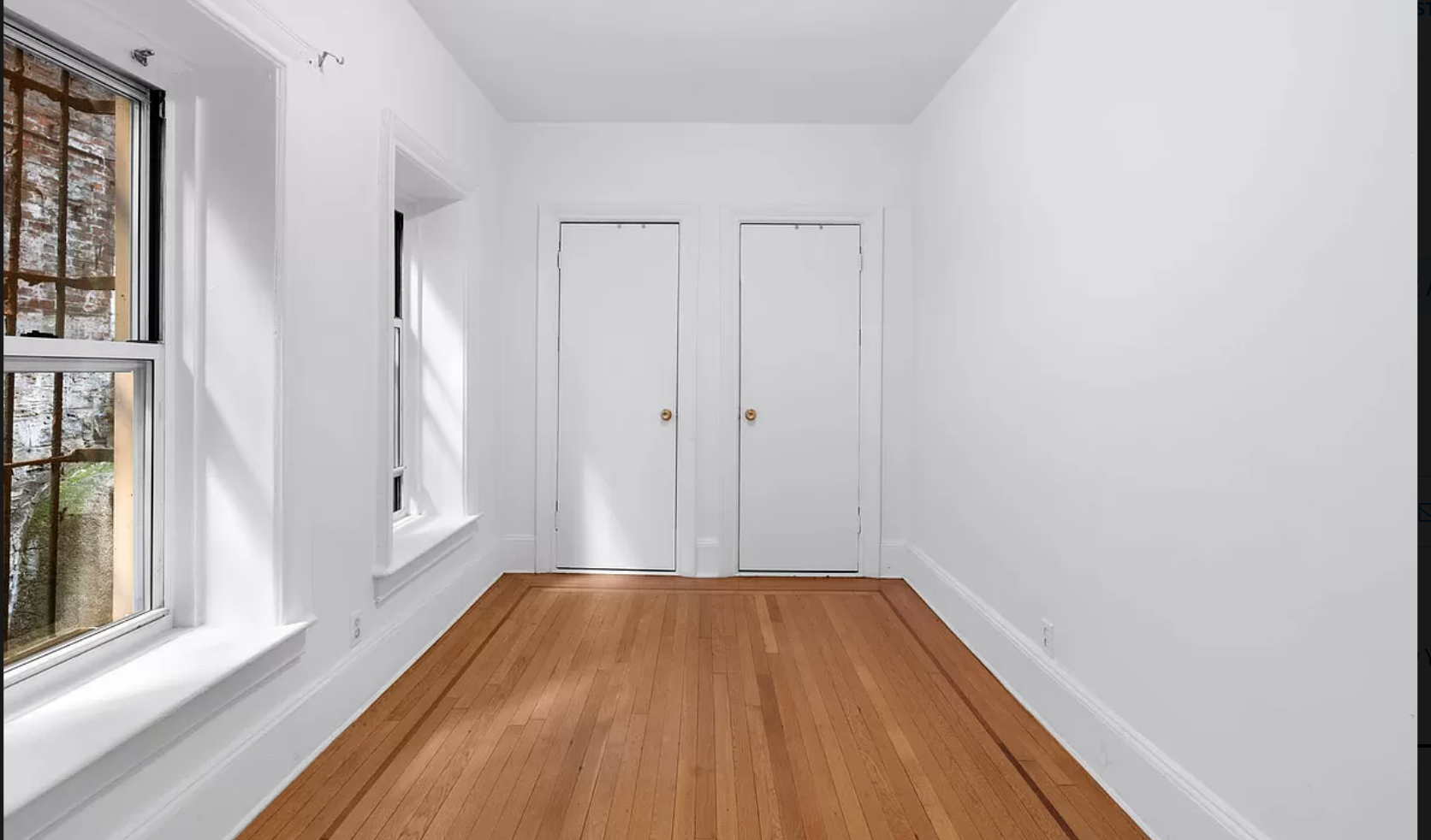104 Bedford Street, Unit 1C Manhattan, NY 10014 - Photo 5 of 12 a view of a room with wooden floor and a window