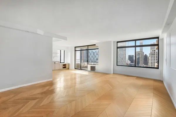 a large white kitchen with a large window and refrigerator