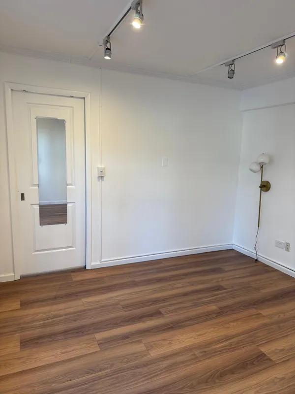 a view of empty room with wooden floor