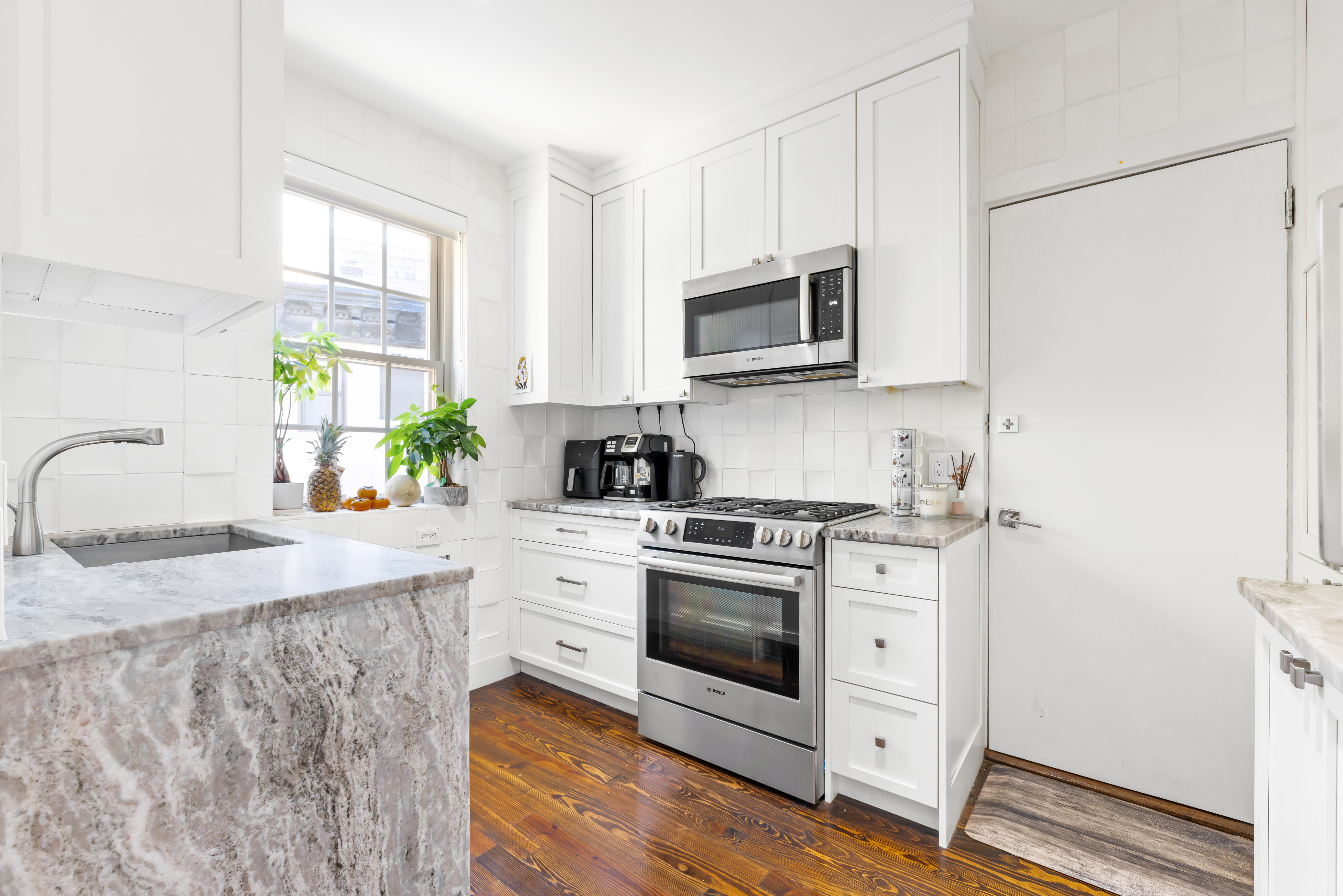 1490 Beacon Street, Unit 4 Brookline, MA 02446 - Photo 8 of 20 a kitchen with stainless steel appliances granite countertop a sink a stove a microwave a refrigerator a counter space and cabinets