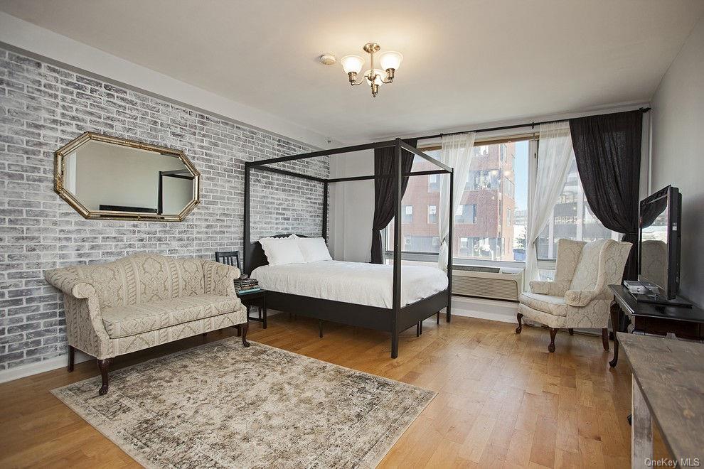 13-11 Jackson Avenue, Unit 4C Queens, NY 11101 - Photo 1 of 7 a bedroom with a bed a couch and dresser