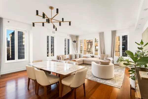 a dining room with wooden floor a chandelier a wooden table and chairs