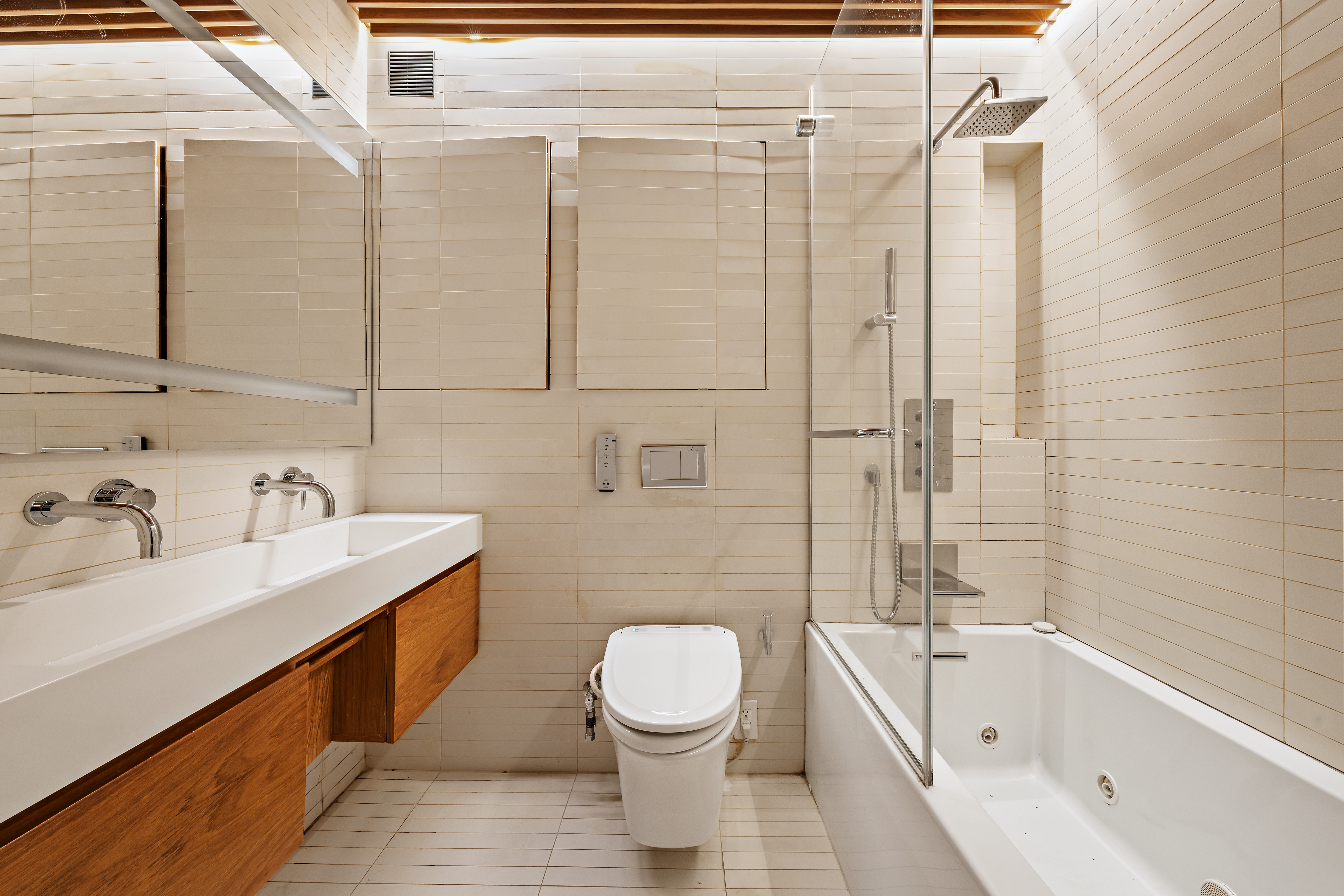 280 Rector Place, Unit 5IJ Manhattan, NY 10280 - Photo 5 of 10 a bathroom with a bathtub shower sink mirror and toilet