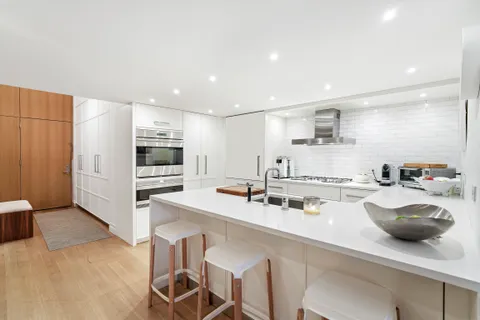 a kitchen with a sink a stove and chairs