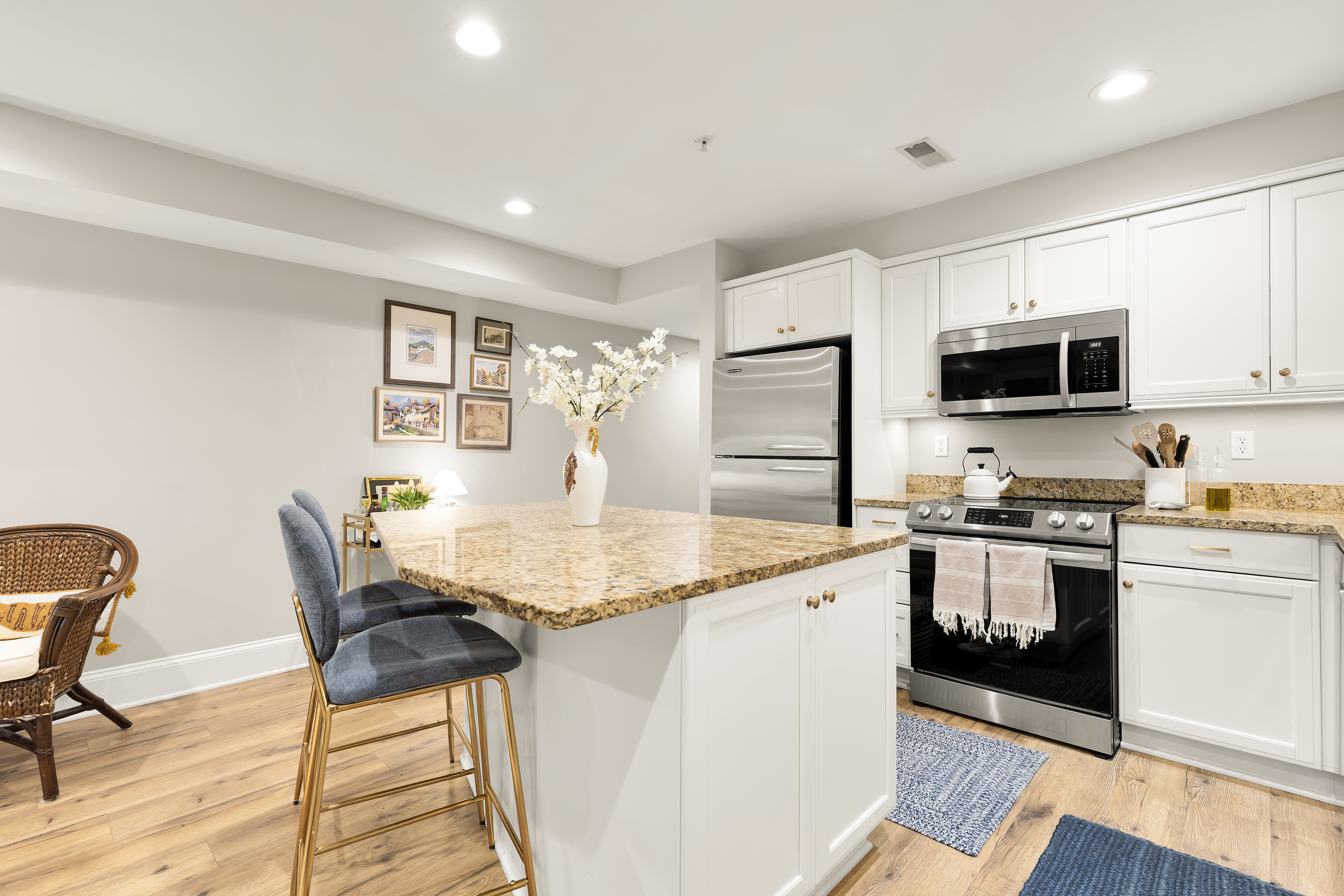 1354 Kenyon Street Northwest, Unit G Washington, DC 20010 - Photo 11 of 35 a kitchen with stainless steel appliances granite countertop a stove a sink a microwave a dining table and chairs