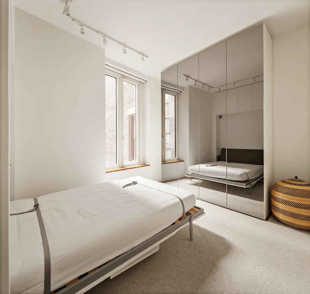 a bedroom with a bed lamp and a window