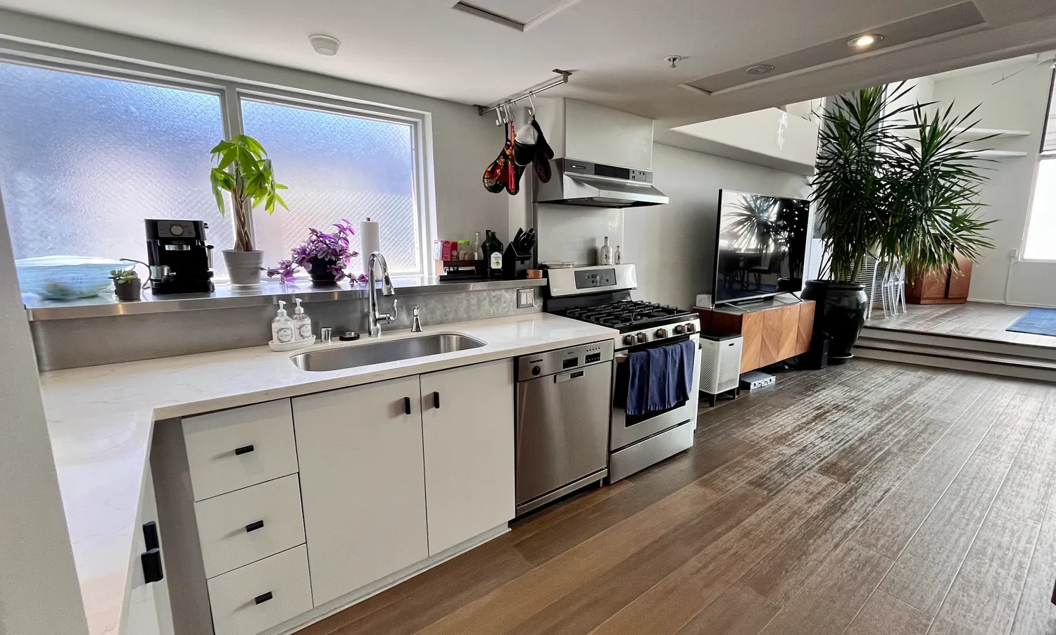 a kitchen with kitchen island granite countertop a sink cabinets and wooden floor