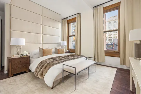 a bed sitting in a bedroom next to a window