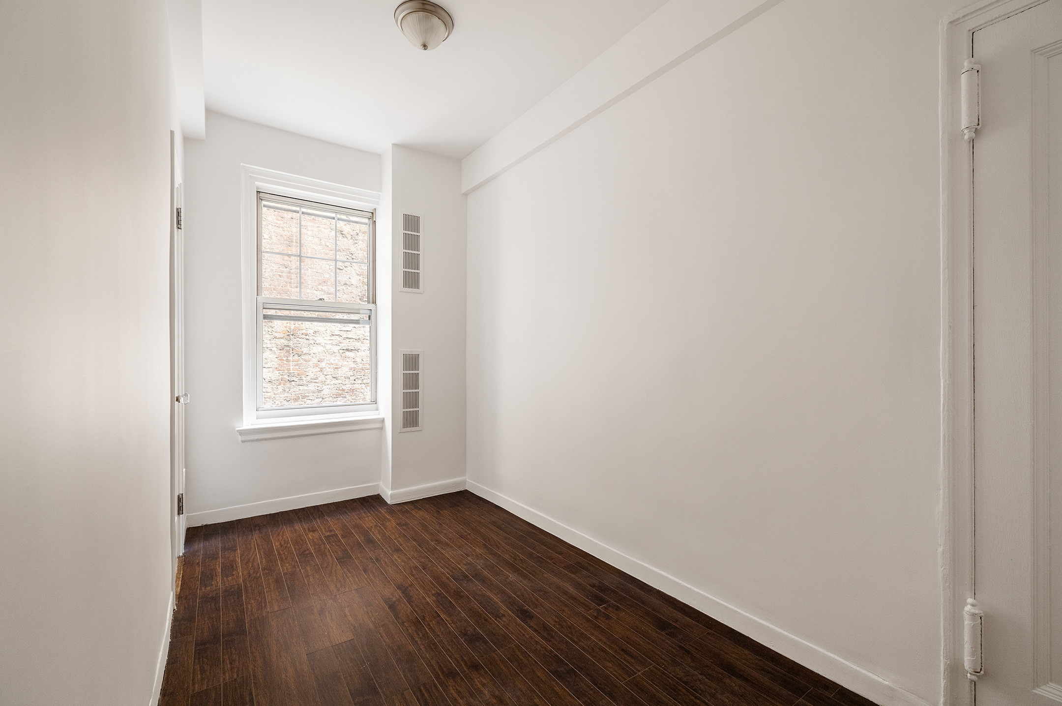 310 West End Avenue, Unit 2A Manhattan, NY 10023 - Photo 15 of 19 an empty room with wooden floor and windows