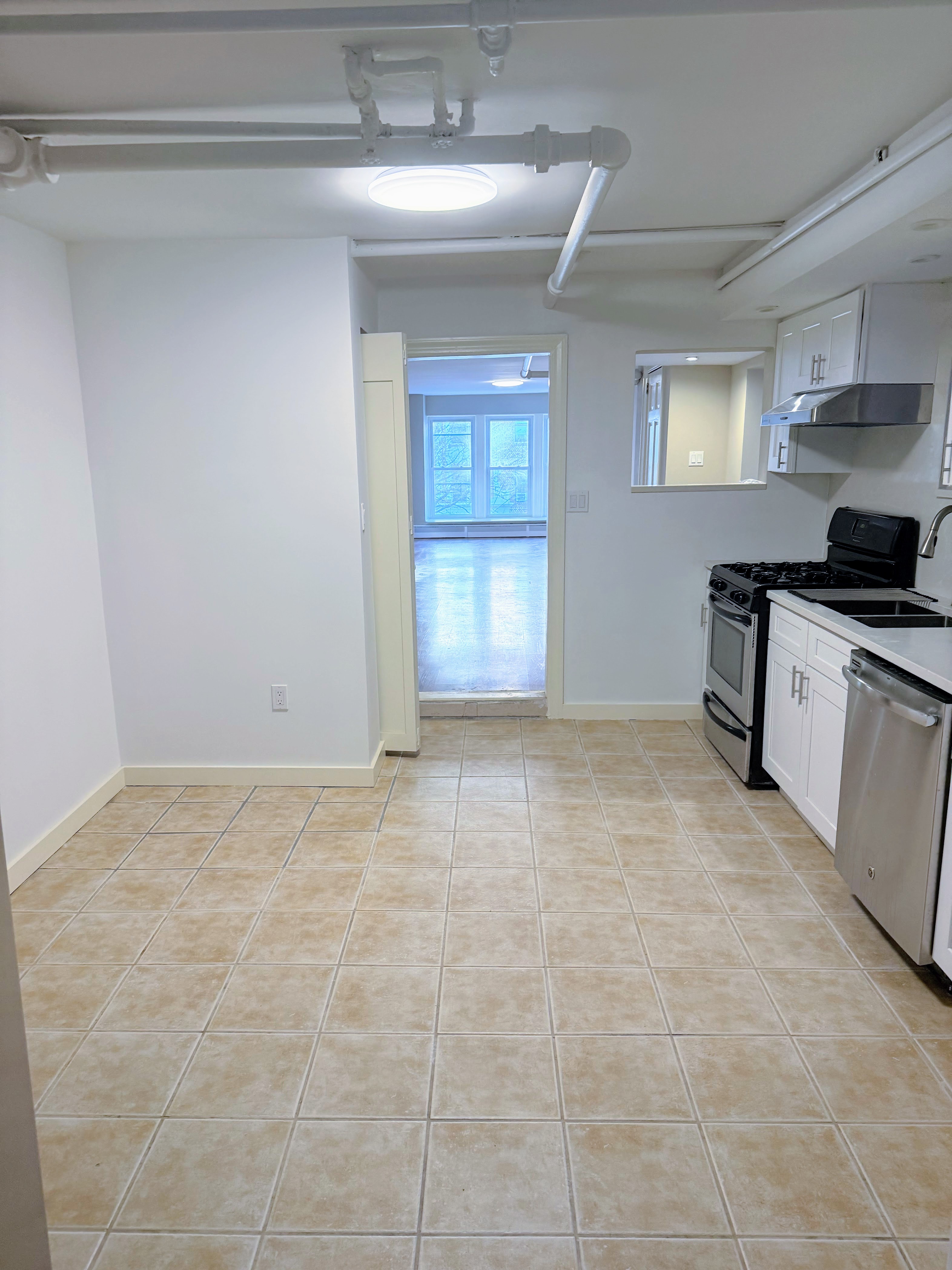 642 West 207th Street, Unit 1 Manhattan, NY 10034 - Photo 5 of 11 a view of a kitchen with a sink cabinets and a window