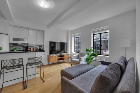 a living room with furniture and a flat screen tv with wooden floor