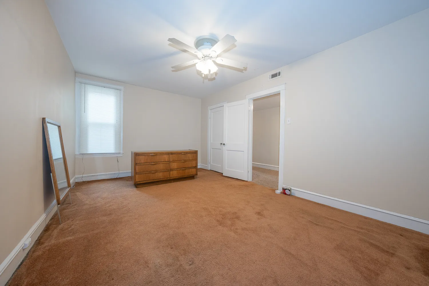 a view of an empty room with a chandelier fan