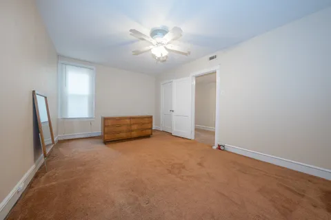 a view of an empty room with a chandelier fan