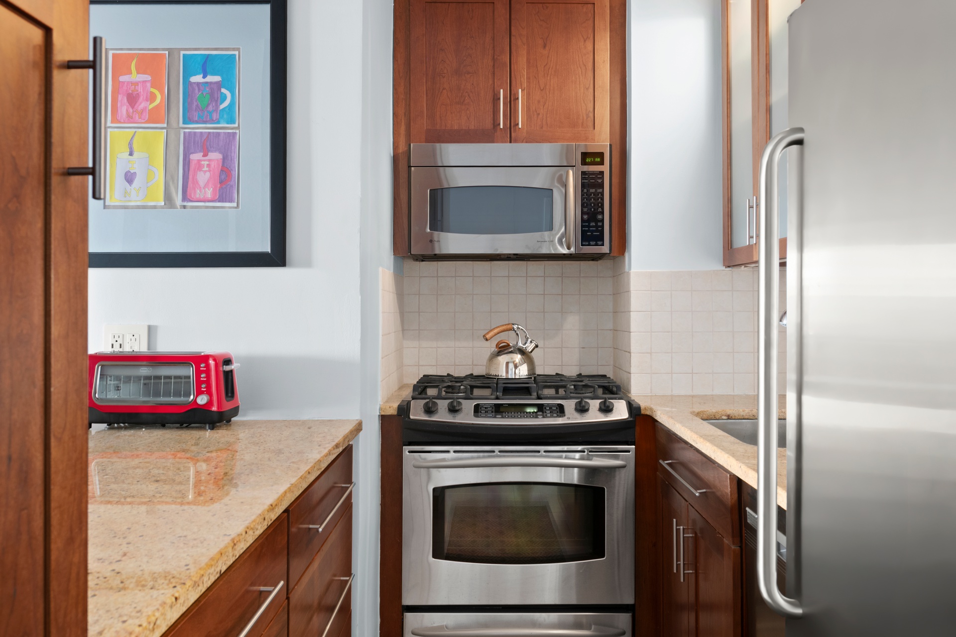 10 West 66th Street, Unit 7C Manhattan, NY 10023 - Photo 4 of 19 a kitchen with stainless steel appliances granite countertop a stove and a microwave