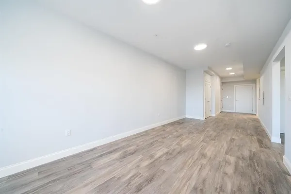 a view of empty room with wooden floor