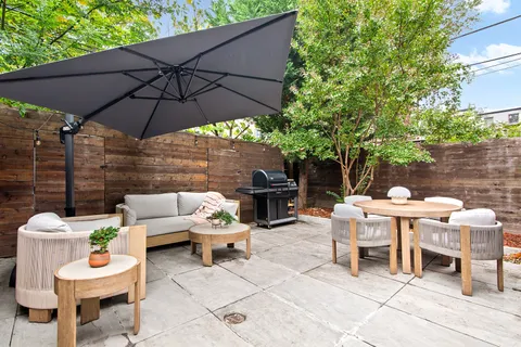 a view of a patio with a table and chairs under an umbrella